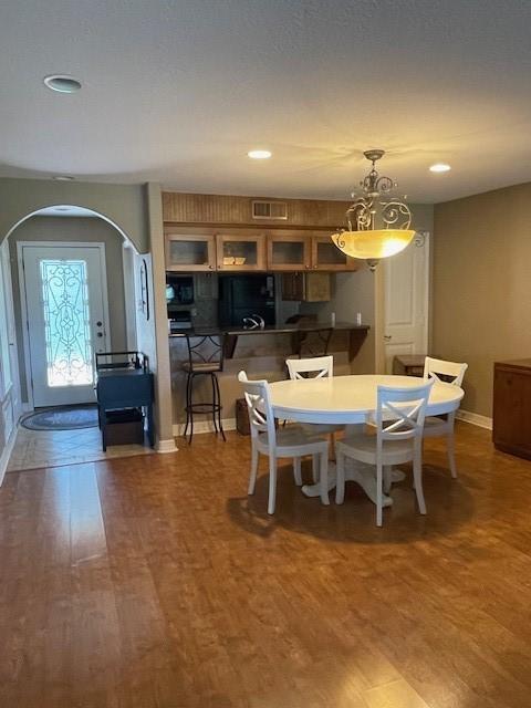 52 April Hl Unit 52, Conroe, TX 77356 - dining room featuring arched walkways, wood finished floors, baseboards, and recessed lighting