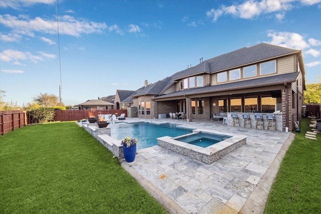 2011 Greenvine Cir, Katy, TX 77494 - rear view of house featuring a patio area, brick siding, a pool with connected hot tub, an outdoor living space with a fire pit, and a shingled roof