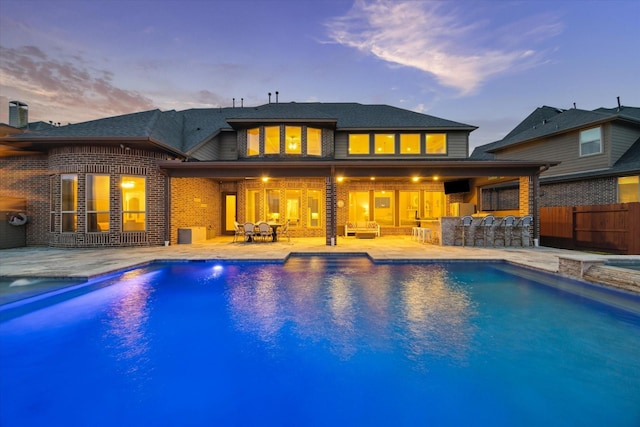 2011 Greenvine Cir, Katy, TX 77494 - back of house at dusk featuring a patio, brick siding, and fence