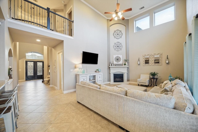 2011 Greenvine Cir, Katy, TX 77494 - living room featuring a towering ceiling, a glass covered fireplace, arched walkways, light tile patterned flooring, and ceiling fan