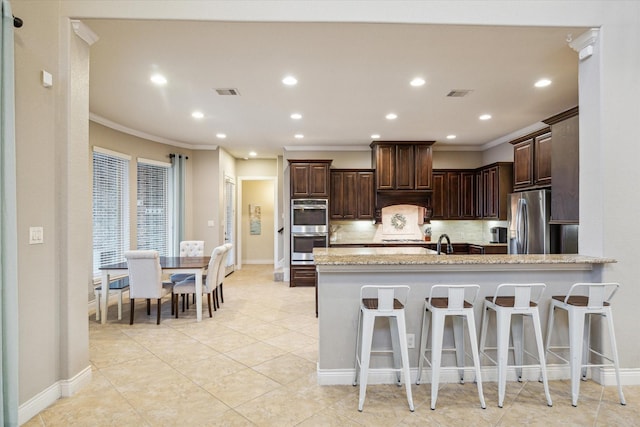 2011 Greenvine Cir, Katy, TX 77494 - kitchen with stainless steel appliances, ornamental molding, backsplash, dark brown cabinets, and baseboards
