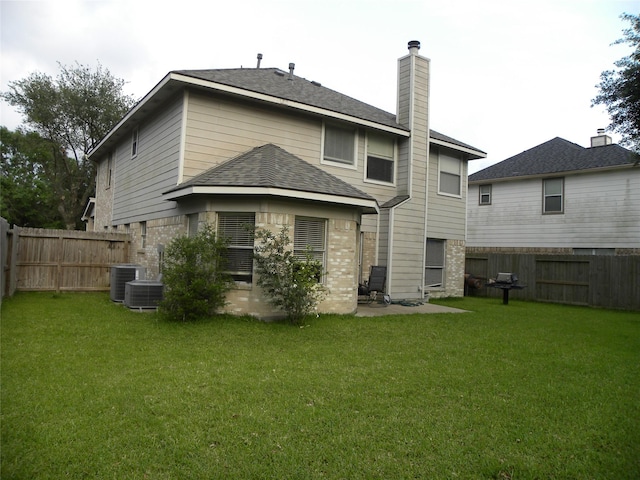 back of property with roof with shingles, brick siding, a chimney, and central AC unit