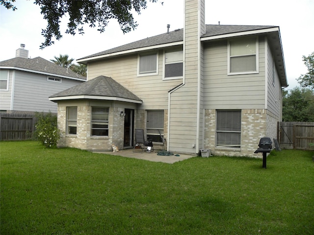 rear view of house featuring brick siding, a patio area, a chimney, and roof with shingles