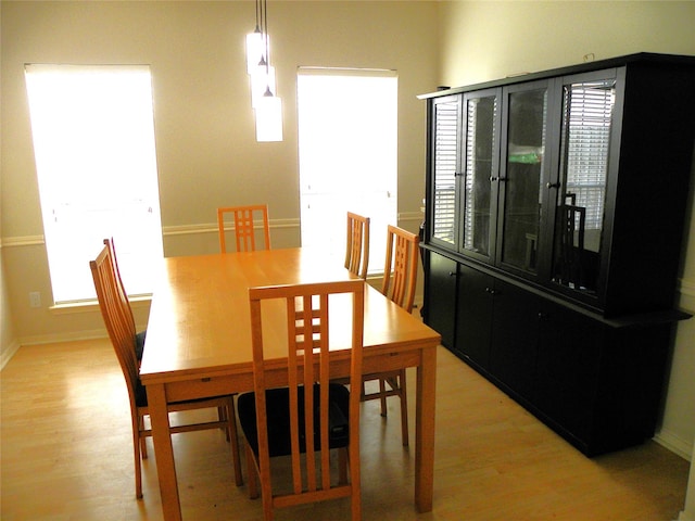 dining area featuring light wood finished floors, baseboards, and plenty of natural light