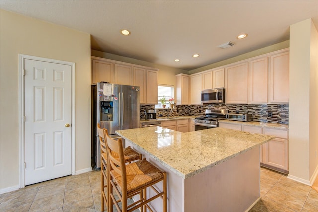 1635 Pebble Banks, Pasadena, TX 77586 - kitchen featuring stainless steel appliances, decorative backsplash, a sink, a kitchen island, and light stone countertops
