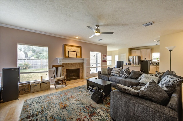1635 Pebble Banks, Pasadena, TX 77586 - living room with light wood-type flooring, ceiling fan, a textured ceiling, ornamental molding, and a fireplace