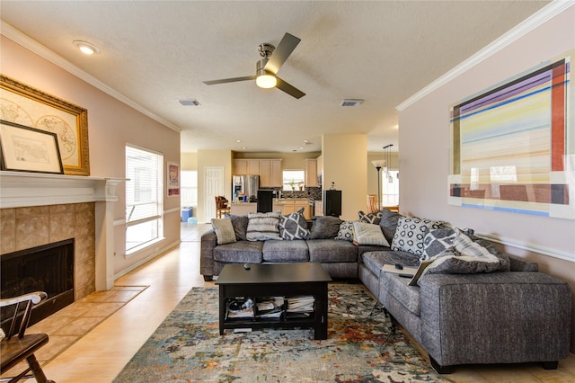 1635 Pebble Banks, Pasadena, TX 77586 - living room with ceiling fan, ornamental molding, a tiled fireplace, a textured ceiling, and light wood finished floors