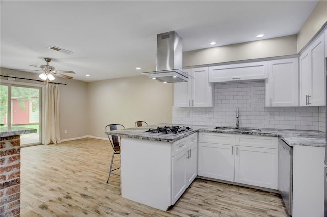 5810 Verdome Ln, Houston, TX 77092 - kitchen featuring island range hood, a sink, stainless steel appliances, a peninsula, and backsplash