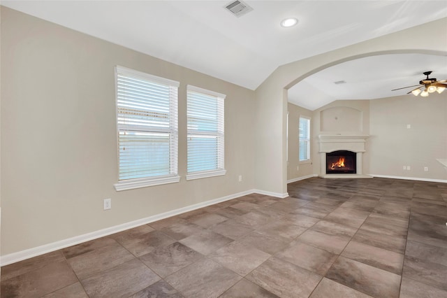 19219 S Cottonwood Green Ln, Cypress, TX 77433 - unfurnished living room with vaulted ceiling, a ceiling fan, arched walkways, baseboards, and a lit fireplace