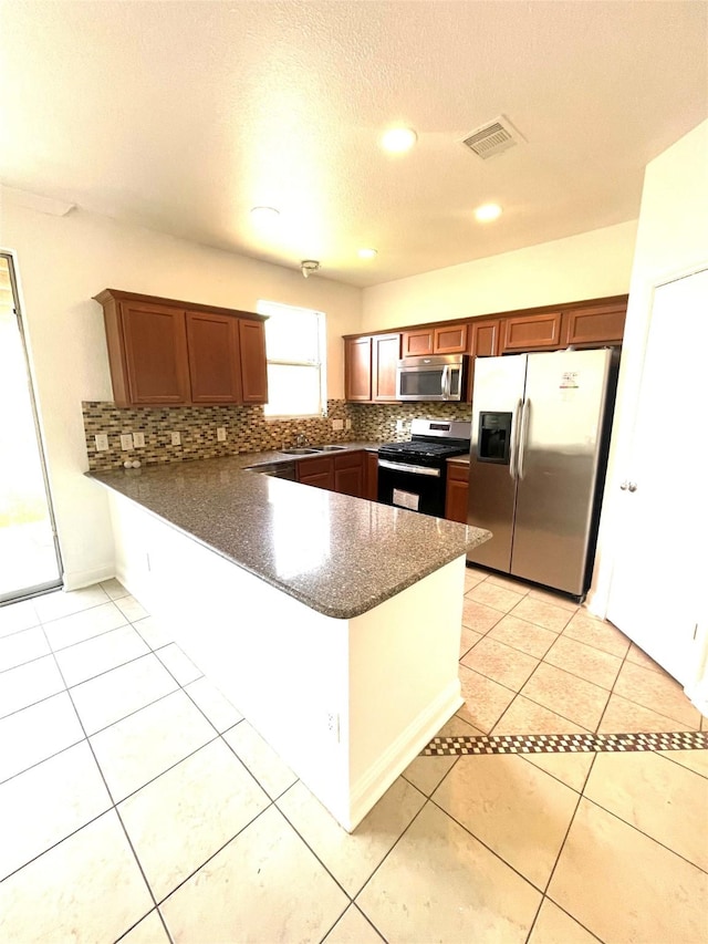 13150 Lawsons Creek Ln, Houston, TX 77072 - kitchen featuring appliances with stainless steel finishes, a peninsula, tasteful backsplash, a sink, and recessed lighting