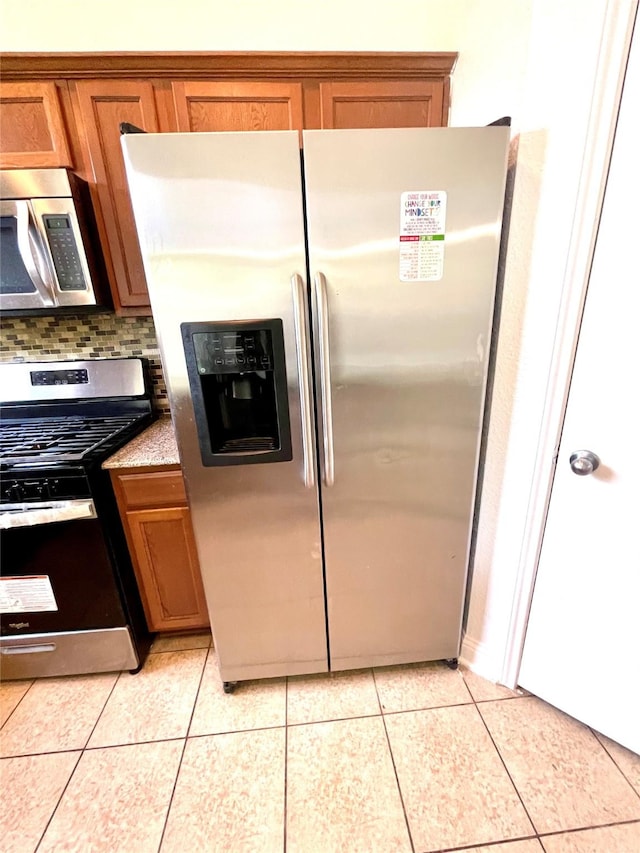 13150 Lawsons Creek Ln, Houston, TX 77072 - kitchen with appliances with stainless steel finishes, brown cabinets, light tile patterned floors, and decorative backsplash