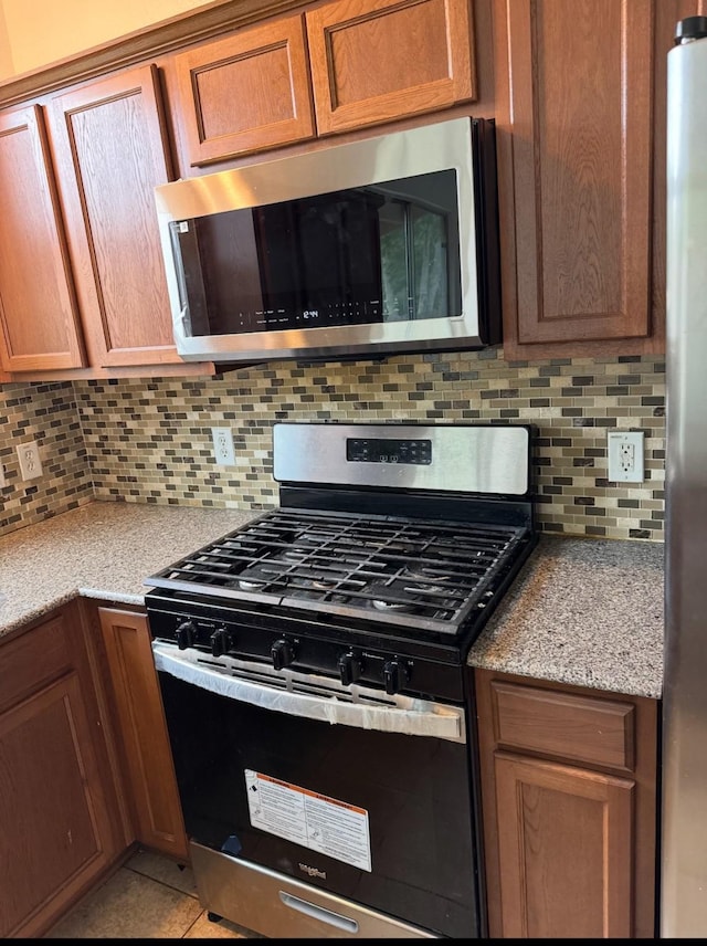 13150 Lawsons Creek Ln, Houston, TX 77072 - kitchen with appliances with stainless steel finishes, backsplash, and brown cabinets