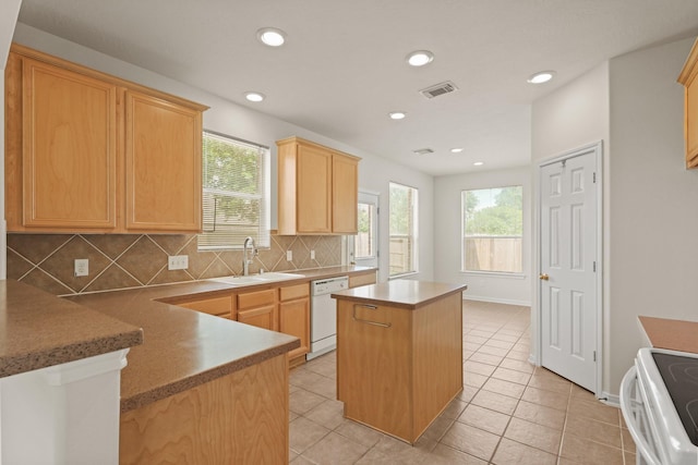 kitchen featuring range with electric cooktop, a sink, white dishwasher, a kitchen island, and backsplash