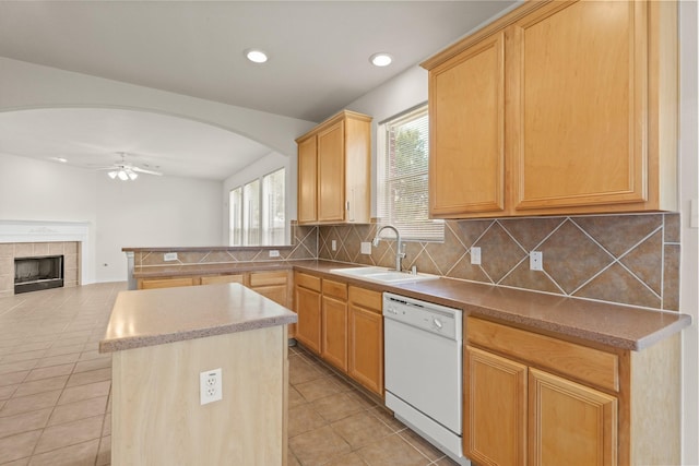 kitchen featuring dishwasher, a sink, light tile patterned flooring, backsplash, and ceiling fan