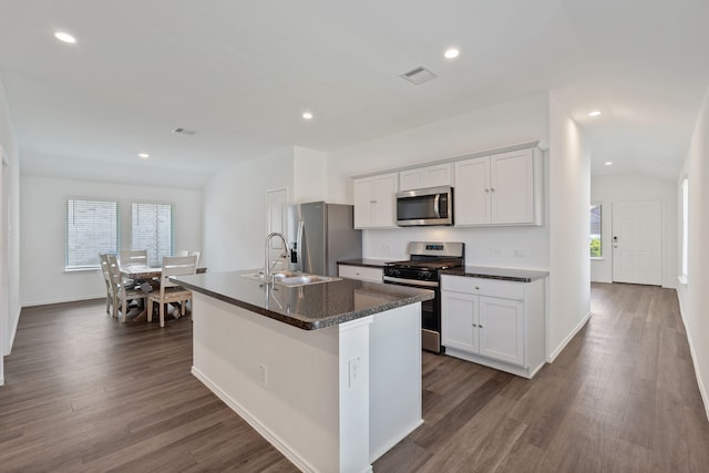 kitchen featuring appliances with stainless steel finishes, a sink, a kitchen island with sink, dark wood-style floors, and white cabinetry