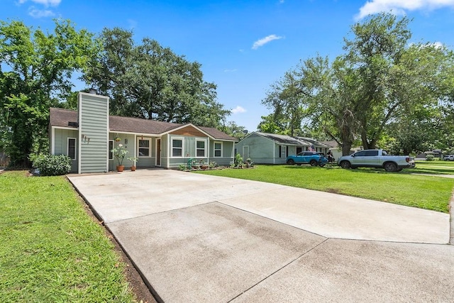 view of front of home with concrete driveway, a front lawn, and a chimney