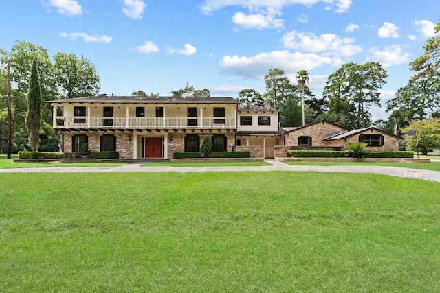 3310 Riviera Ln, Houston, TX 77338 - view of front of house with a front lawn, brick siding, and a balcony