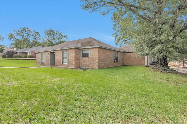 445 Augusta Dr, Huntsville, TX 77340 - view of property exterior featuring a yard, brick siding, and roof with shingles