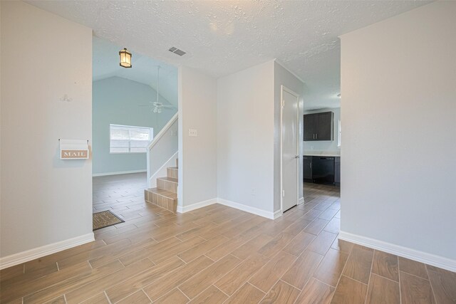 20101 Dawn Mist Dr, Humble, TX 77346 - spare room featuring wood finish floors, ceiling fan, baseboards, a textured ceiling, and stairs
