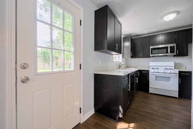 20101 Dawn Mist Dr, Humble, TX 77346 - kitchen with gas range gas stove, stainless steel microwave, a sink, plenty of natural light, and a textured ceiling