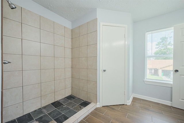 20101 Dawn Mist Dr, Humble, TX 77346 - full bath featuring tiled shower, wood tiled floors, a textured ceiling, and baseboards