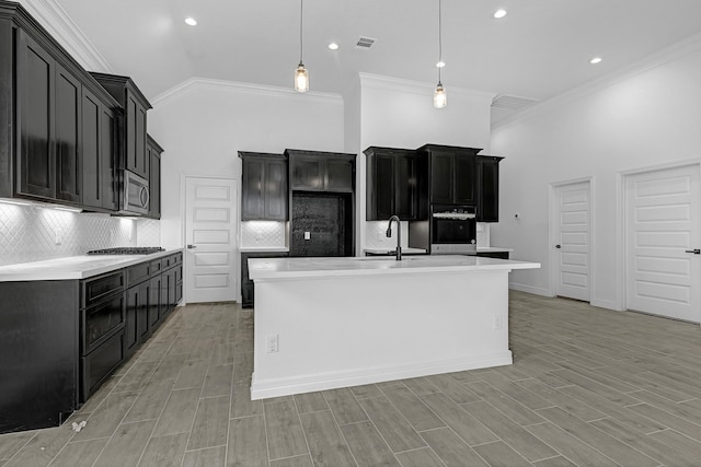 318 Little Spring Ct, Anahuac, TX 77523 - kitchen with appliances with stainless steel finishes, backsplash, a sink, crown molding, and a towering ceiling