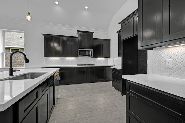318 Little Spring Ct, Anahuac, TX 77523 - kitchen featuring stainless steel appliances, a sink, dark cabinetry, crown molding, and decorative backsplash