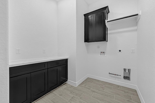 318 Little Spring Ct, Anahuac, TX 77523 - laundry room featuring hookup for a gas dryer, baseboards, hookup for a washing machine, electric dryer hookup, and cabinet space