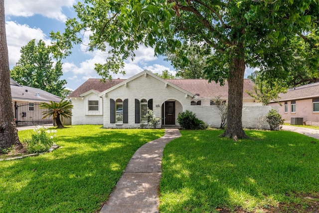 2407 Del Norte St, Houston, TX 77018 - view of front of house featuring central AC unit, a front lawn, brick siding, and roof with shingles