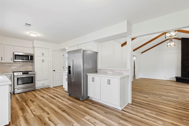 2407 Del Norte St, Houston, TX 77018 - kitchen with appliances with stainless steel finishes, decorative backsplash, light wood-style flooring, light countertops, and white cabinets