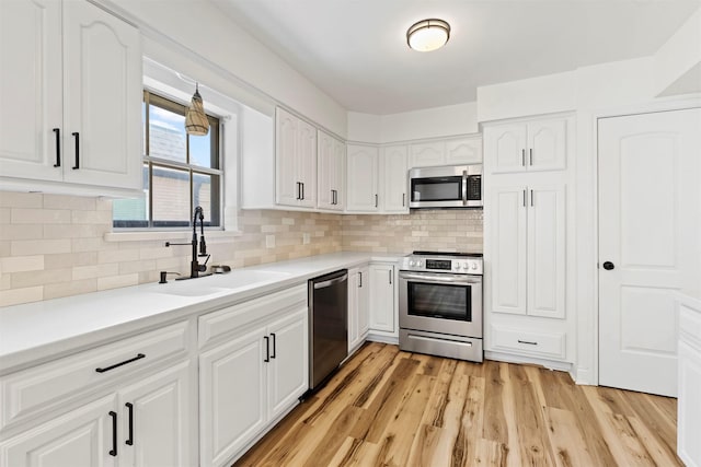 2407 Del Norte St, Houston, TX 77018 - kitchen featuring appliances with stainless steel finishes, a sink, white cabinets, and backsplash