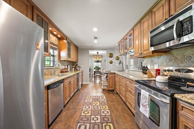 12392 Fm 355, Trinity, TX 75862 - kitchen featuring stainless steel appliances, a sink, dark wood-style floors, backsplash, and brown cabinets
