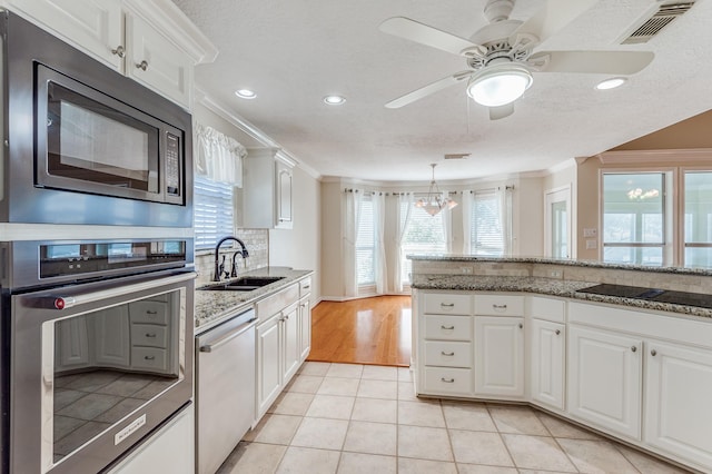 341 Sam, Houston Loop, Point Blank, TX 77364 - kitchen featuring stainless steel appliances, a sink, ornamental molding, white cabinetry, and recessed lighting