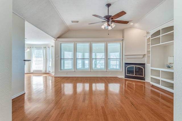 341 Sam, Houston Loop, Point Blank, TX 77364 - unfurnished living room featuring vaulted ceiling, ceiling fan, wood finished floors, a fireplace with flush hearth, and built in features