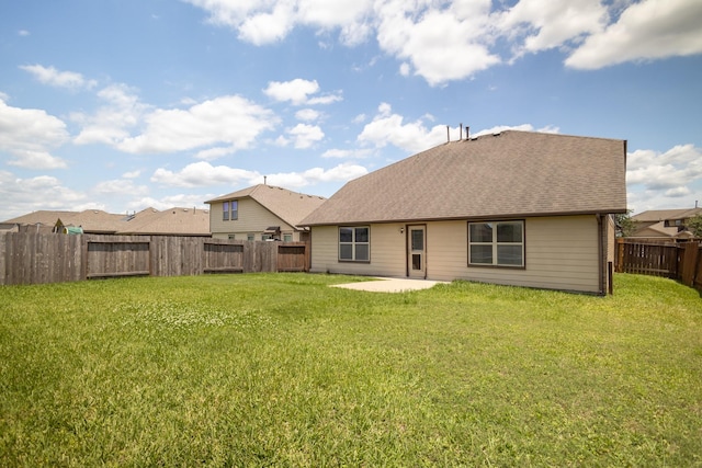 back of property with a patio and roof with shingles