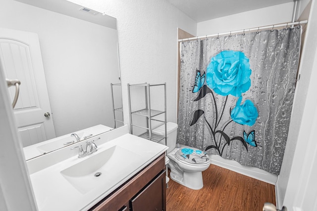 full bath featuring wood finished floors, vanity, and toilet