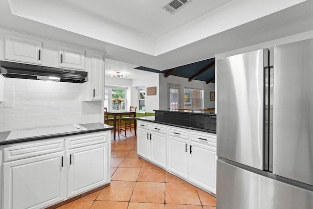 5918 Donwhite Ln, Houston, TX 77088 - kitchen featuring freestanding refrigerator, dark countertops, decorative backsplash, under cabinet range hood, and light tile patterned floors