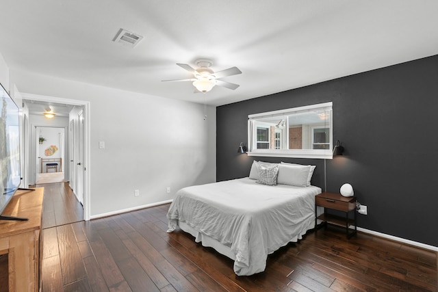 5918 Donwhite Ln, Houston, TX 77088 - bedroom featuring wood-type flooring, baseboards, a ceiling fan, and a fireplace