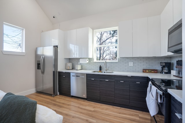 7612 Ave L, Houston, TX 77012 - kitchen featuring appliances with stainless steel finishes, a sink, light countertops, backsplash, and white cabinets