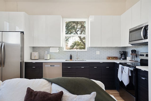 7612 Ave L, Houston, TX 77012 - kitchen with appliances with stainless steel finishes, a sink, light countertops, and white cabinetry
