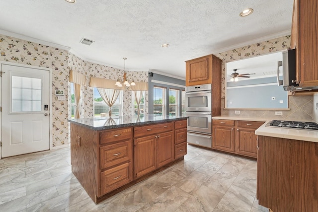 2422 Acadiana Ln, Seabrook, TX 77586 - kitchen with ornamental molding, stainless steel appliances, brown cabinetry, a warming drawer, and a chandelier