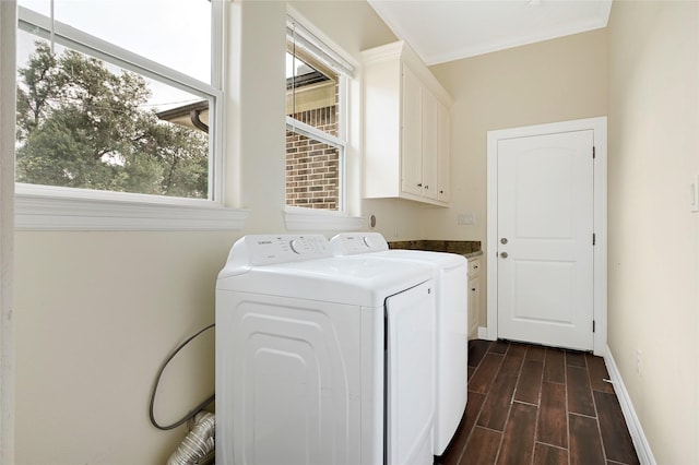 laundry area featuring cabinet space, dark wood-type flooring, baseboards, and washer and clothes dryer