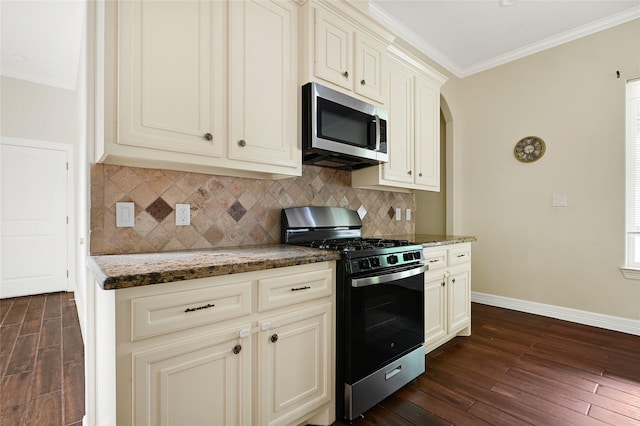 kitchen featuring stainless steel microwave, gas range, dark wood-style floors, baseboards, and crown molding