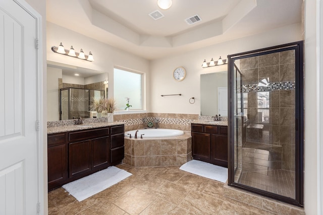 18107 Banpo Ct, Houston, TX 77044 - full bathroom with a garden tub, a shower stall, a tray ceiling, two vanities, and tile patterned floors
