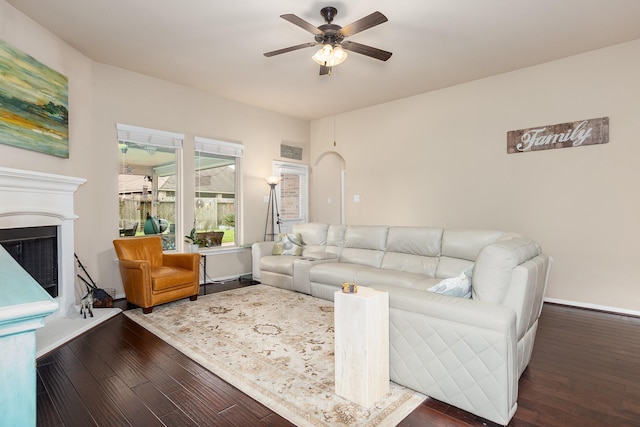 18107 Banpo Ct, Houston, TX 77044 - living area featuring a ceiling fan, a fireplace with raised hearth, wood finished floors, and baseboards