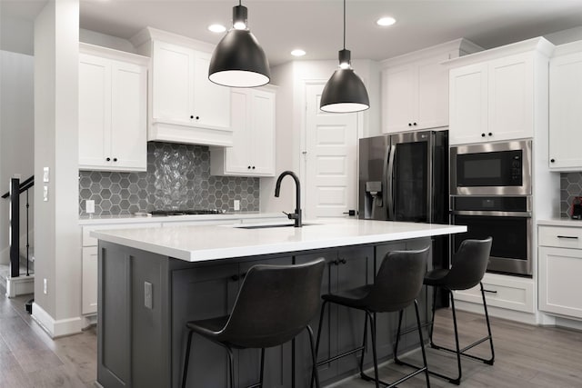 7507 Zion Grove Ct, Katy, TX 77493 - kitchen featuring appliances with stainless steel finishes, light wood-style flooring, a breakfast bar, a sink, and recessed lighting