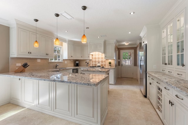 5407 Westminister Ct, Houston, TX 77069 - kitchen featuring freestanding refrigerator, plenty of natural light, a peninsula, backsplash, and crown molding