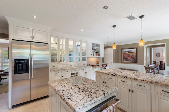 5407 Westminister Ct, Houston, TX 77069 - kitchen featuring stainless steel fridge, crown molding, wainscoting, light stone counters, and glass insert cabinets