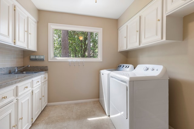 5407 Westminister Ct, Houston, TX 77069 - washroom featuring washing machine and dryer, cabinet space, baseboards, and light tile patterned floors