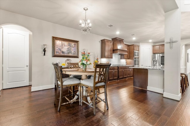 dining room featuring arched walkways, baseboards, dark wood finished floors, a chandelier, and recessed lighting